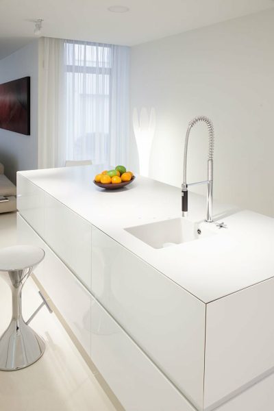 Bowl of fruits on white worktop in modern kitchen